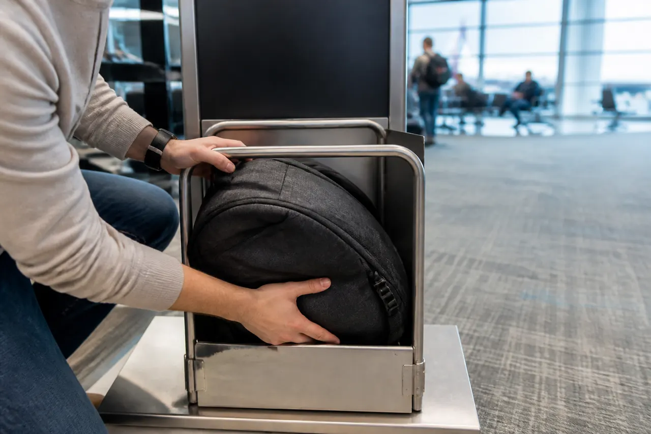 Mãos a colocar uma mochila de cabine num medidor de bagagem simples no aeroporto